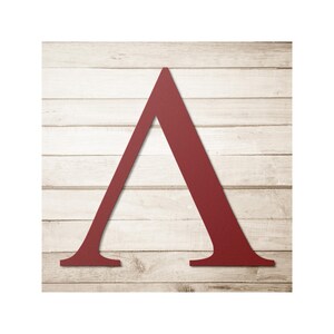 Puede incluir: Una gran letra A de color burdeos, sobre un fondo de tablones de madera horizontales de color claro. La letra tiene un diseño simple y audaz, con una base plana y una parte superior puntiaguda. La veta de la madera añade un toque rústico.