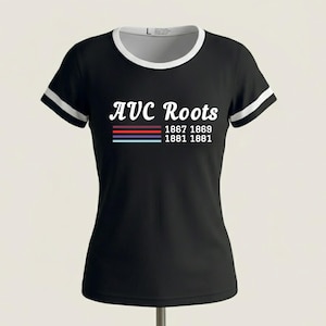 Peut inclure: Une tasse en céramique blanche avec une anse noire et le texte "But First, Coffee" en gras noir. La tasse est posée sur un fond neutre, soulignant son design simple.