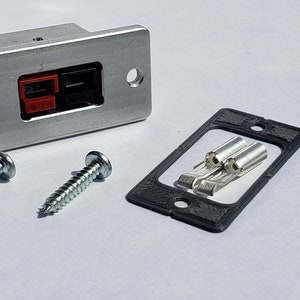 May include: A silver metal electrical outlet plate with two black and red terminal connectors, two screws, and a black rubber gasket.
