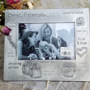 May include: Silver-toned picture frame with a photo of three friends laughing. The frame has an inscription that reads "Best Friends..." and includes phrases like "long talks", "good times", "shopping sprees", "warm smiles", "shoulder to lean on", "best pal", "loyal & true", "coffee talks", and "celebrations".