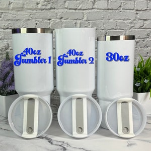 May include: Three white stainless steel tumblers with lids. The tumblers are labeled with blue text: "40oz Tumbler 1", "40oz Tumbler 2", and "30oz".