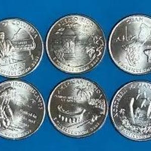 May include: Six US quarter coins featuring different state and territory designs. The coins include District of Columbia, Puerto Rico, Guam, Virgin Islands, American Samoa, and Northern Mariana Islands. Each coin has detailed imagery and text.