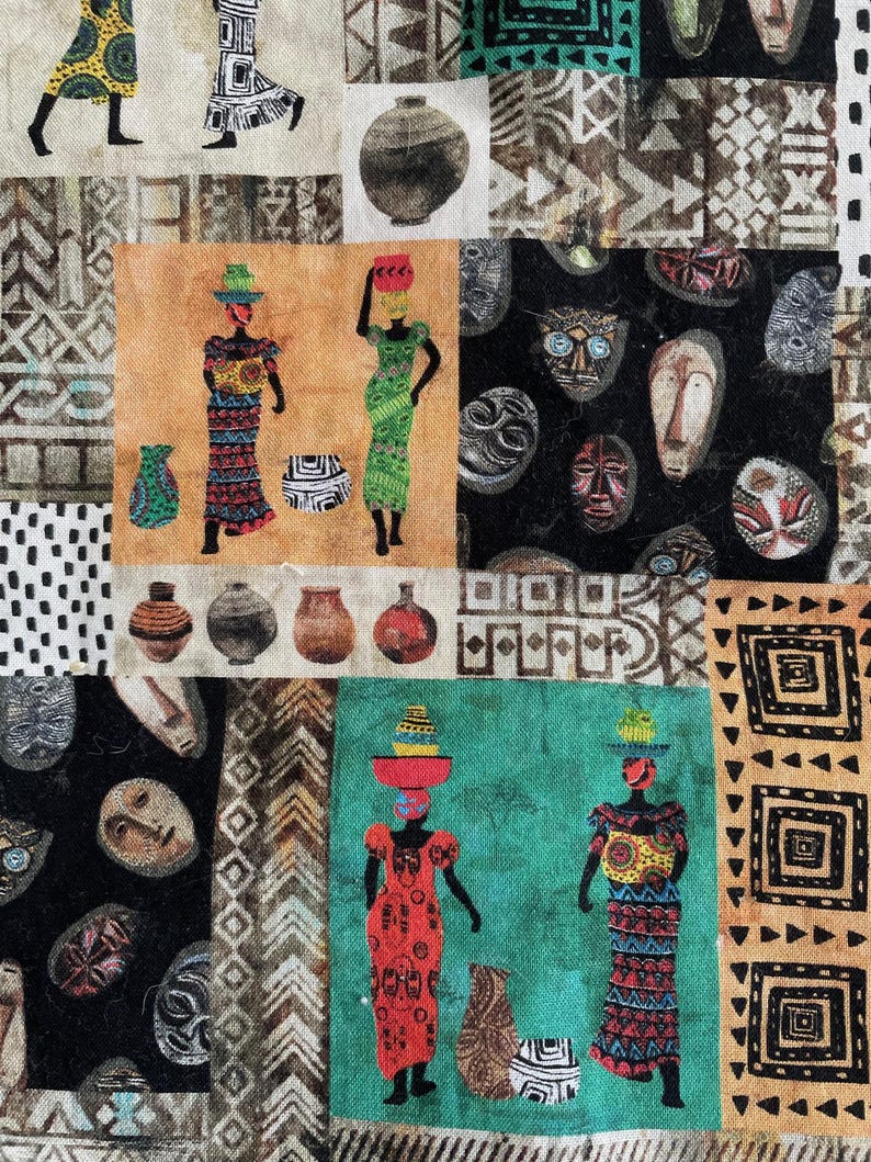 May include: A colorful fabric with a repeating pattern of African masks, geometric shapes, and stylized figures. The fabric features a variety of colors, including black, white, brown, red, green, and blue.
