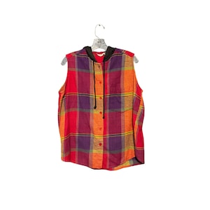 May include: Sleeveless plaid shirt in red, orange, purple, and yellow. The shirt has a black hood with a drawstring and a button-down front. The shirt is hanging on a silver hanger against a white background.