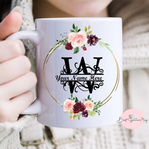 May include: White ceramic mug with a gold rim and floral design. The mug features a black monogram with the letters "W" and "A" and the text "Your Name Here".
