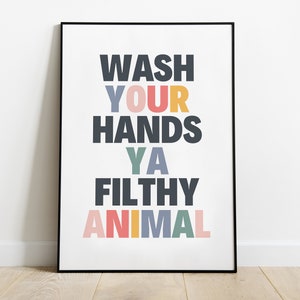 May include: A framed poster with the text "WASH YOUR HANDS YA FILTHY ANIMAL" in colorful letters on a white background.