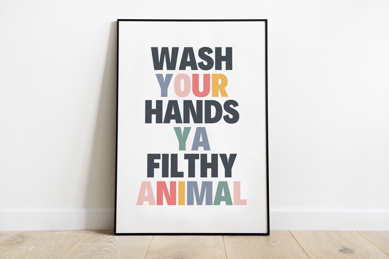 May include: A framed poster with the text "WASH YOUR HANDS YA FILTHY ANIMAL" in colorful letters on a white background.