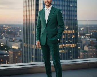 May include: A smart green suit, paired with a white shirt and black shoes. The suit is a solid colour and looks to be made from a smooth material. The person is standing on a rooftop with a city skyline in the background.