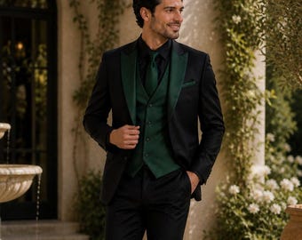 May include: A black suit with a green satin lapel, vest, and tie. The suit is worn with a black shirt. The man is standing outside near a fountain and greenery. The suit is a formal style.
