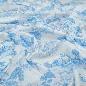May include: White fabric with a blue and white repeating pattern of a countryside landscape. The fabric is wrinkled and folded.