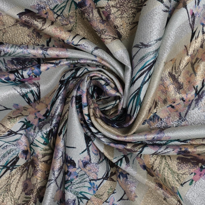 May include: Silver fabric with a floral print in shades of pink, gold, and teal. The fabric has a subtle shimmer.