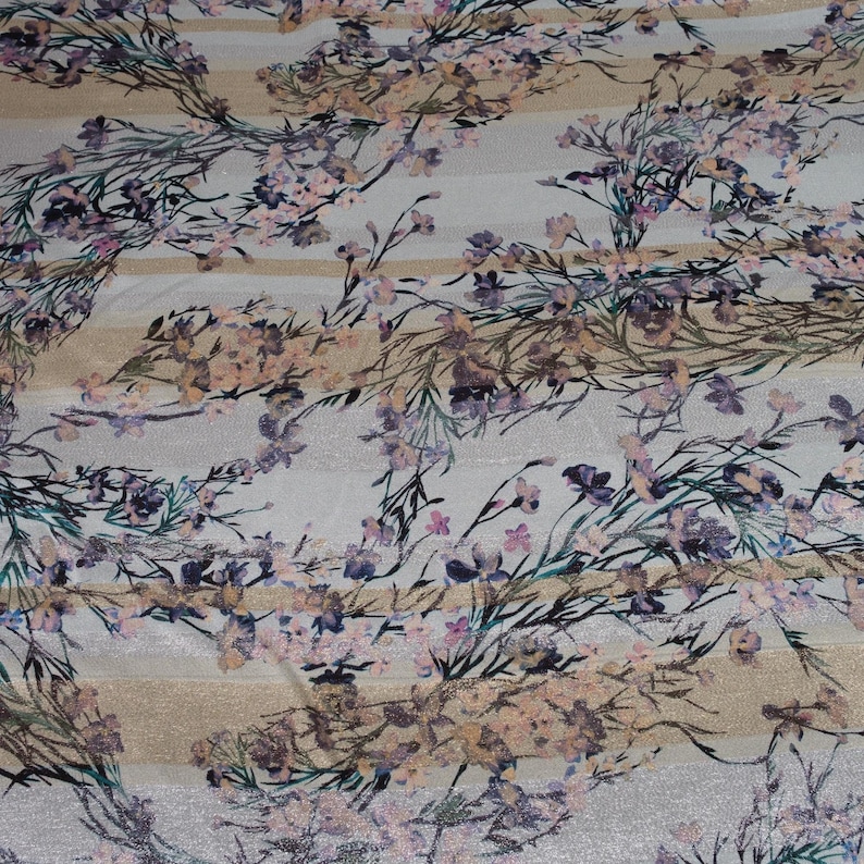May include: White fabric with a floral print featuring pink, purple, and brown flowers on a background of beige and white stripes.