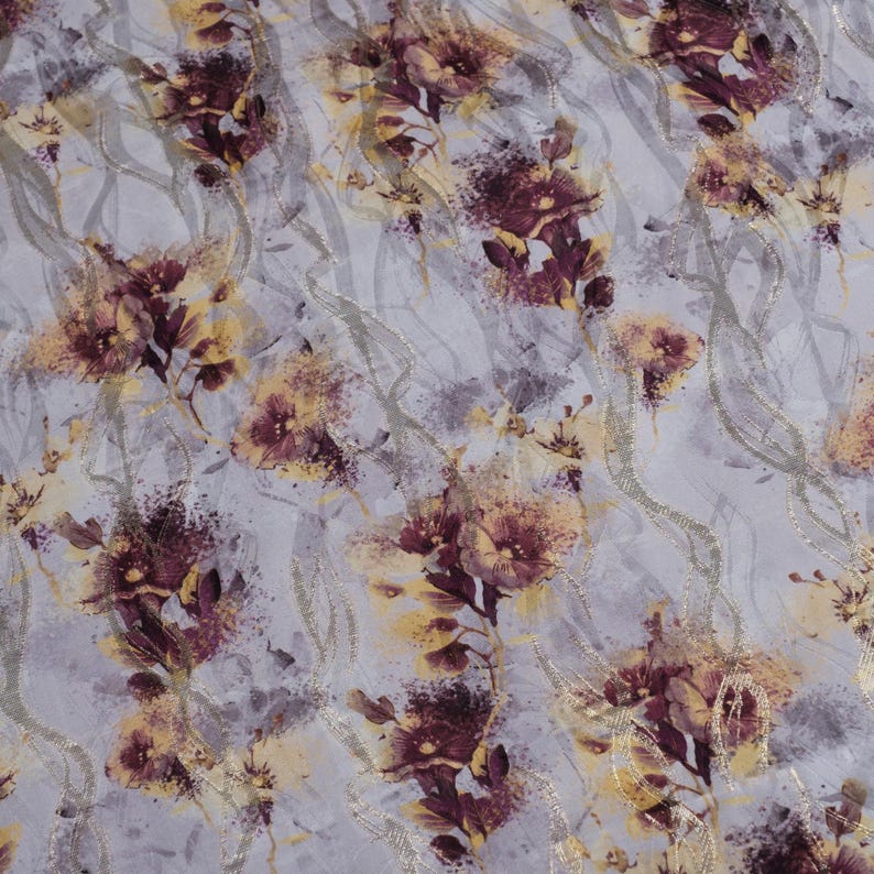 May include: A gray fabric with a floral pattern. The flowers are a mix of burgundy and yellow.