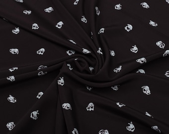 May include: Black fabric with a repeating pattern of white bunny illustrations. The fabric is draped, showing folds and shadows. The bunnies are depicted in a simple, cartoonish style, scattered across the surface.