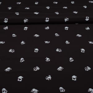 May include: Black fabric with a repeating pattern of white bunny illustrations. The bunnies are depicted in various poses, creating a playful and whimsical design. The fabric appears to be soft and suitable for various sewing projects.