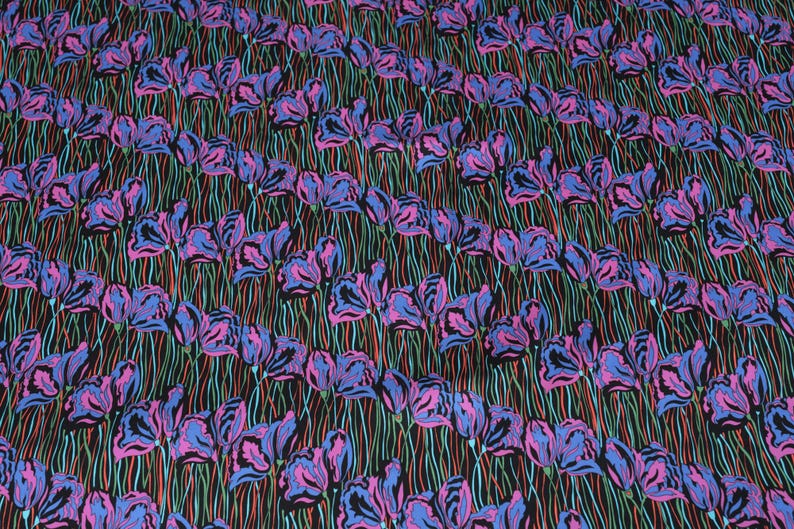 May include: A black fabric with a repeating pattern of pink and blue stylised flowers. The flowers are outlined in black and have a white centre.