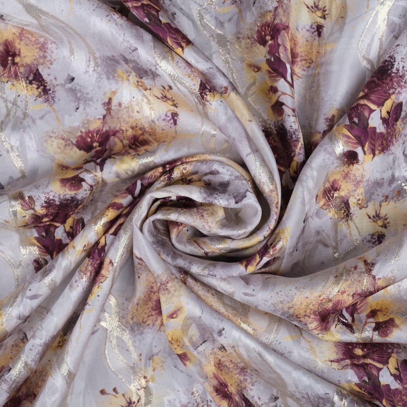 May include: White fabric with a floral print in shades of burgundy, gold, and gray. The fabric has a subtle sheen and a soft, flowing texture.
