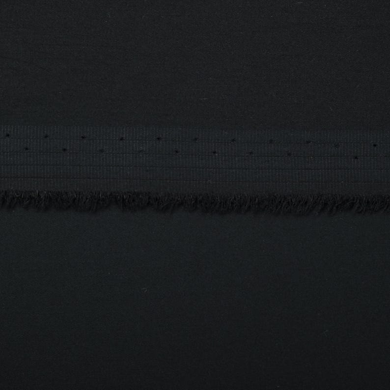 May include: Black fabric with a black elastic band and a fringed edge.