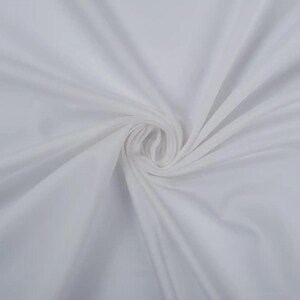 May include: White fabric with a smooth, silky texture. The fabric is folded and draped, creating soft folds and curves.