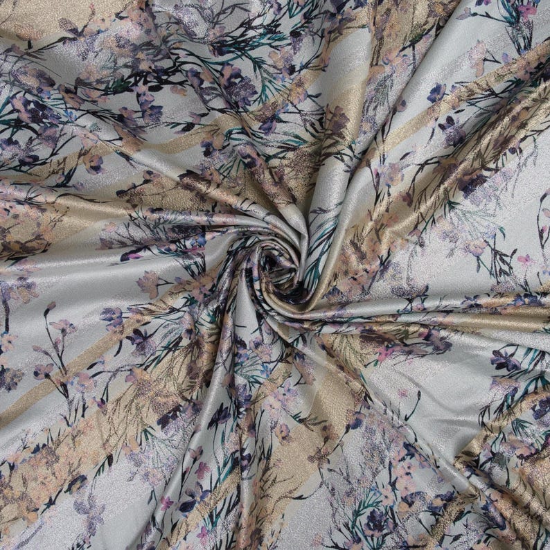 May include: Silver fabric with a gold and pink floral print. The fabric has a subtle shimmer and a soft texture.