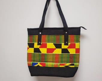 May include: Black tote bag with a zipper closure and black straps. The bag is made of a woven fabric with a colorful geometric pattern in shades of yellow, red, green, and black.