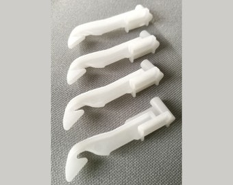 May include: Four white plastic curtain hooks with a hook on one end and a clip on the other end.
