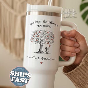 May include: White insulated tumbler with a handle, featuring a tree with red apples and a child reaching for one. The text reads, "Never forget the difference you make." Below the illustration is "Mrs. Jones" and a small red heart.
