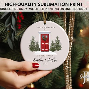 May include: White ceramic Christmas ornament with a red door, two pine trees, and the text "First Christmas at 248 Joran Drive Emilia + Joshna 2024".
