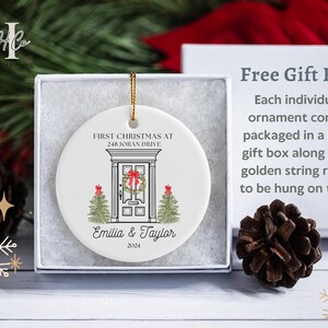 May include: White ceramic Christmas ornament with a house illustration and the text "First Christmas at 248 Joran Drive Emilia & Taylor 2024".