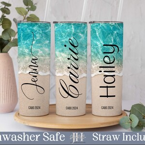 Puede incluir: Tres vasos de acero inoxidable personalizados con una escena de playa y los nombres "Jenna", "Barrie" y "Hailey" impresos en ellos. Cada vaso tiene el texto "CABO 2024" impreso en la parte inferior.