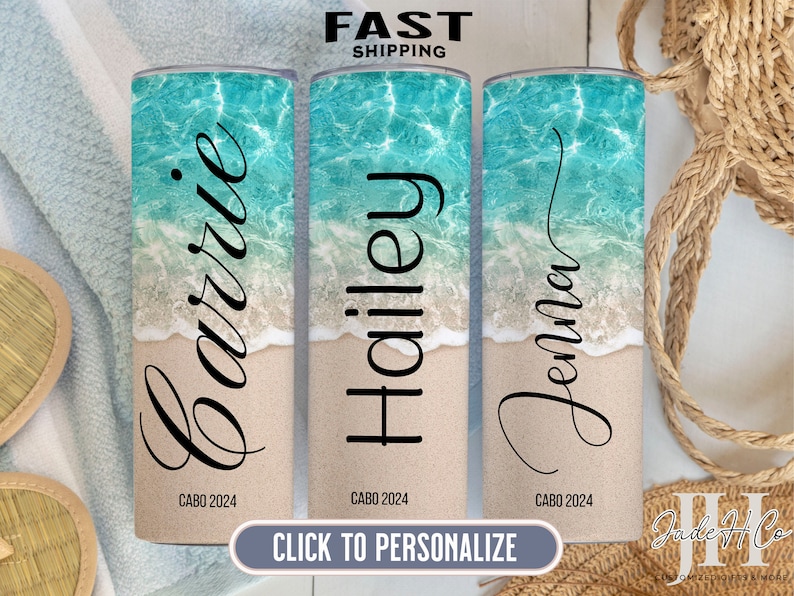 Puede incluir: Tres vasos de acero inoxidable personalizados con un fondo de escena de playa. Los vasos son blancos con un dise&ntilde;o de ola de oc&eacute;ano azul y el texto "CABO 2024" en la parte inferior. Los nombres "Carrie", "Hailey" y "Jenna" est&aacute;n escritos en cursiva negra en los vasos.