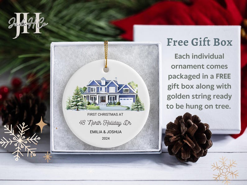 May include: White ceramic Christmas ornament with a watercolor painting of a blue house. The ornament reads "First Christmas at 48 North Holiday Dr. Emilia & Joshua 2024".