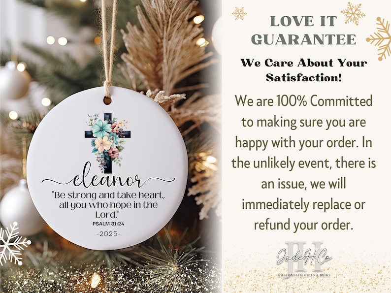 May include: A white ceramic Christmas ornament with a floral cross design and the name "eleanor". The ornament includes the text "Be strong and take heart, all you who hope in the Lord." Psalm 31:24 -2025-.