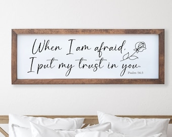 May include: A wooden framed sign with the text "When I am afraid, I put my trust in you. Psalm 56:3" in black cursive font. A small stylized flower is to the right of the text.
