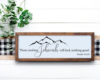 May include: A framed wood sign with a white background and black text. The sign features a mountain range graphic and the text "Those seeking Jehovah will lack nothing good. -Psalm 34:10".