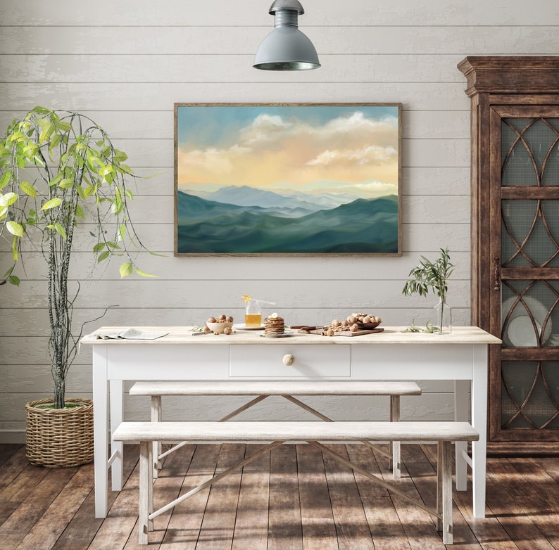 May include: A white farmhouse table with a drawer and two benches. The table is set with a plate of nuts, a glass of juice, and a plate of pastries. A framed landscape painting hangs on the wall behind the table.