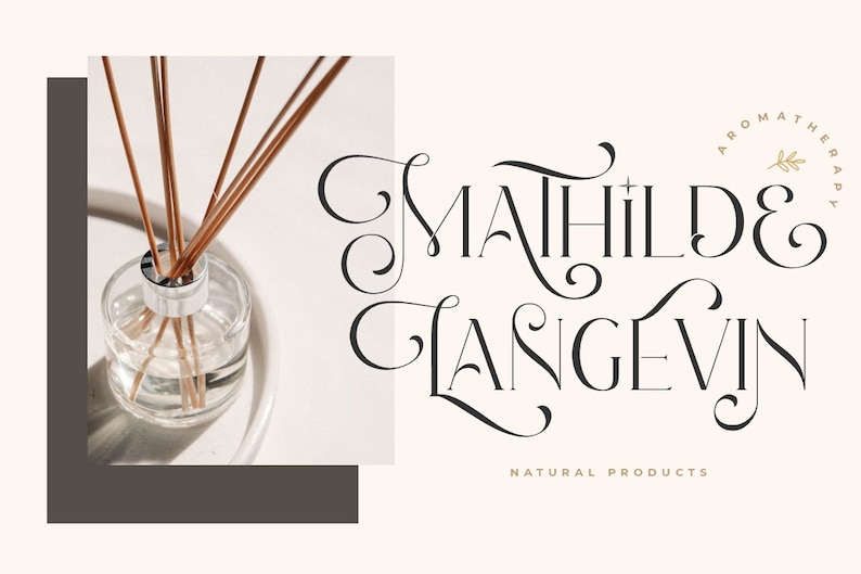 K&ouml;nnte beinhalten: Eine klare Glasflasche mit einem silbernen Deckel und braunen St&auml;bchen im Inneren. Die Flasche steht auf einer wei&szlig;en Oberfl&auml;che. Der Text "Mahilde & Langevin" ist in einer dekorativen Schriftart mit einem goldenen Blattdesign geschrieben. Der Text "Naturprodukte" steht unter dem Namen.