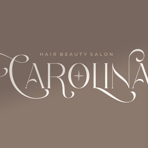 K&ouml;nnte beinhalten: Ein wei&szlig;es Logo mit dem Text "CAROLINA" in einer dekorativen Schriftart. Der Text "HAIR BEAUTY SALON" befindet sich oberhalb des Logos in einer kleineren Schriftart.