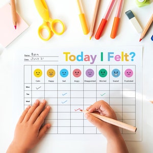 Op de afbeelding: Een stemmingstracker-kaart voor kinderen met een kleurrijke titel "Vandaag voelde ik me?" en een raster met vinkjes voor elke dag van de week. De kaart bevat emoji's die verschillende emoties voorstellen: kalm, blij, verdrietig, boos, teleurgesteld, bezorgd, bang en gefrustreerd.