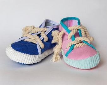 May include: Two fabric shoes with rope laces. One shoe is blue with white trim and the other is pink with turquoise trim.