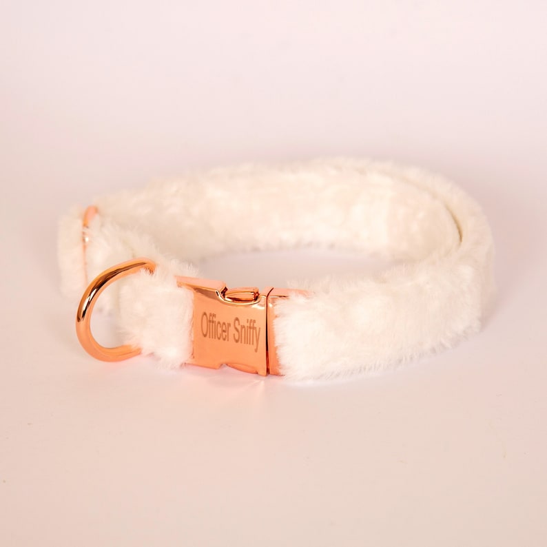 May include: A white faux fur dog collar with a rose gold metal buckle and D-ring. The buckle is engraved with the text "Officer Sniffy".
