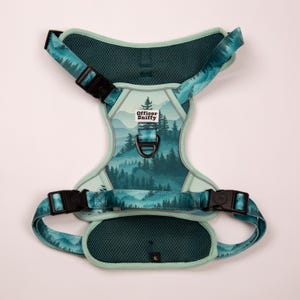 Op de afbeelding: Een teal en groene hondentuig met een bosontwerp. De tuig heeft verstelbare bandjes, zwarte gespen en de tekst "Officer Sniffy". De tuig is gemarkeerd met XL.