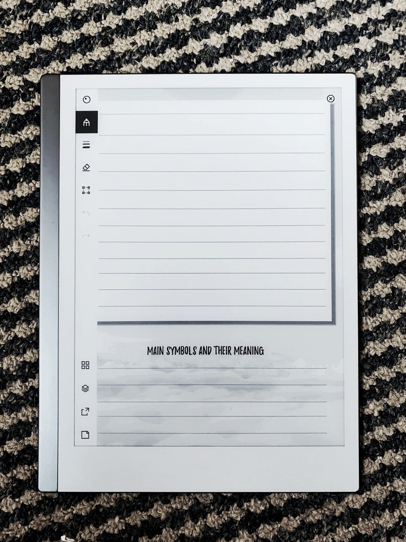 K&ouml;nnte beinhalten: Ein wei&szlig;er E-Reader mit schwarzem Rand und grauem Hintergrund. Der Bildschirm zeigt eine linierte Seite mit dem Text "Main Symbols and Their Meaning".