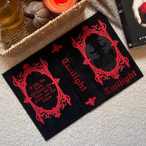Pode incluir: Capa de livro preta com texto e design gótico vermelho. A palavra "Twilight" é exibida em destaque. Um lado apresenta a citação: "I like the dark. Without the dark, we'd never see the stars."