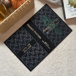 May include: A copy of "Harry Potter and the Deathly Hallows" with a black cover and gold lettering. The cover design includes a geometric pattern and the words "Until the Very End."