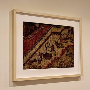 May include: A framed print of a close-up of a colorful rug with intricate patterns.