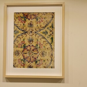 May include: A framed print of a vintage floral pattern in shades of red, yellow, blue, and green. The pattern is reminiscent of a traditional rug or tapestry.