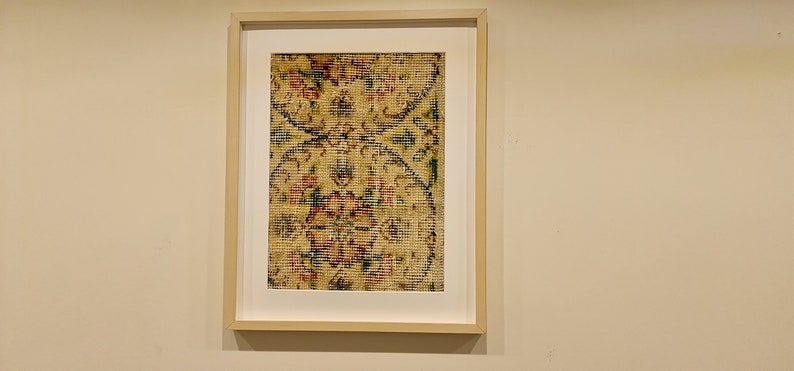 May include: A framed print of a vintage floral pattern in shades of red, yellow, blue, and green. The pattern is reminiscent of a traditional rug or tapestry.