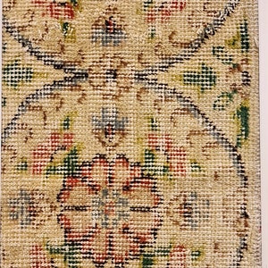 May include: A framed piece of needlepoint with a floral design in shades of red, green, blue, and beige.