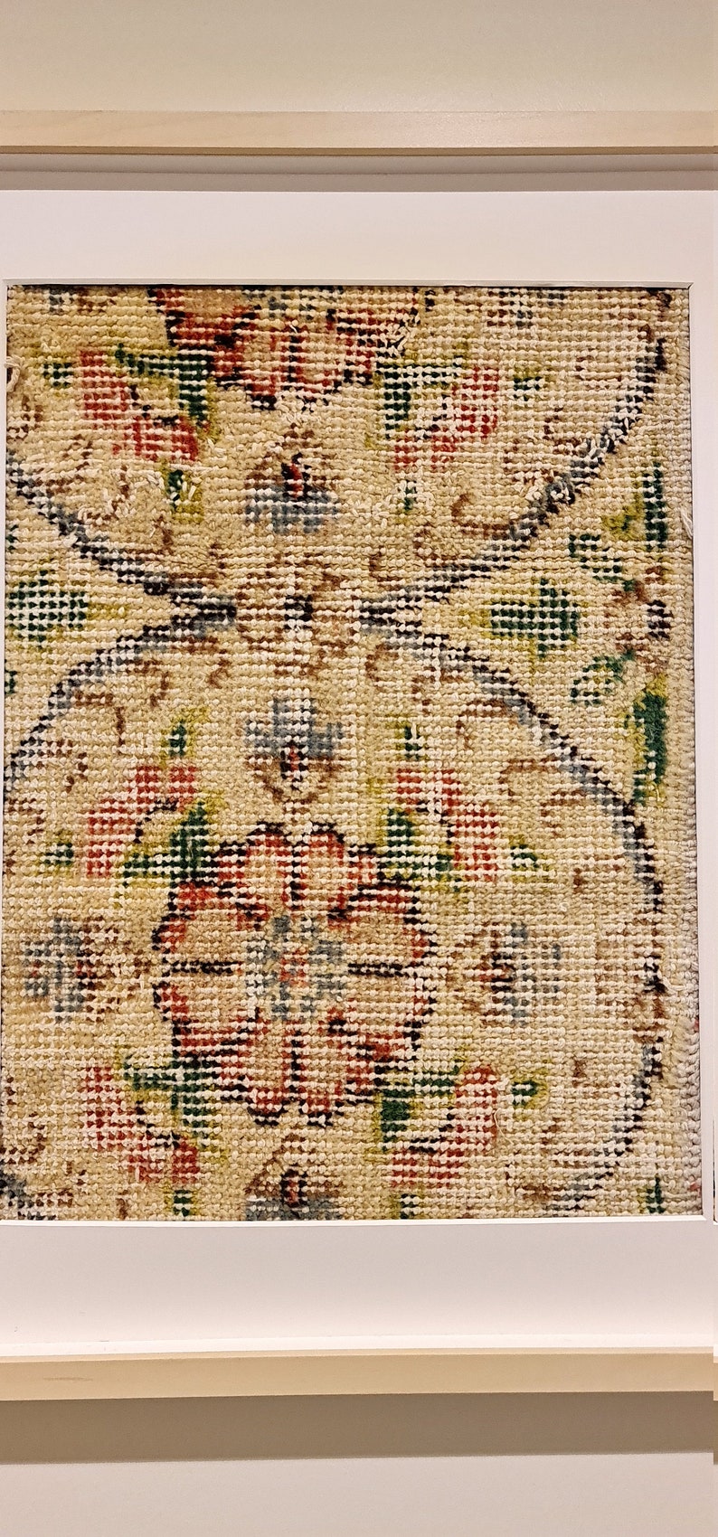 May include: A framed piece of needlepoint with a floral design in shades of red, green, blue, and beige.